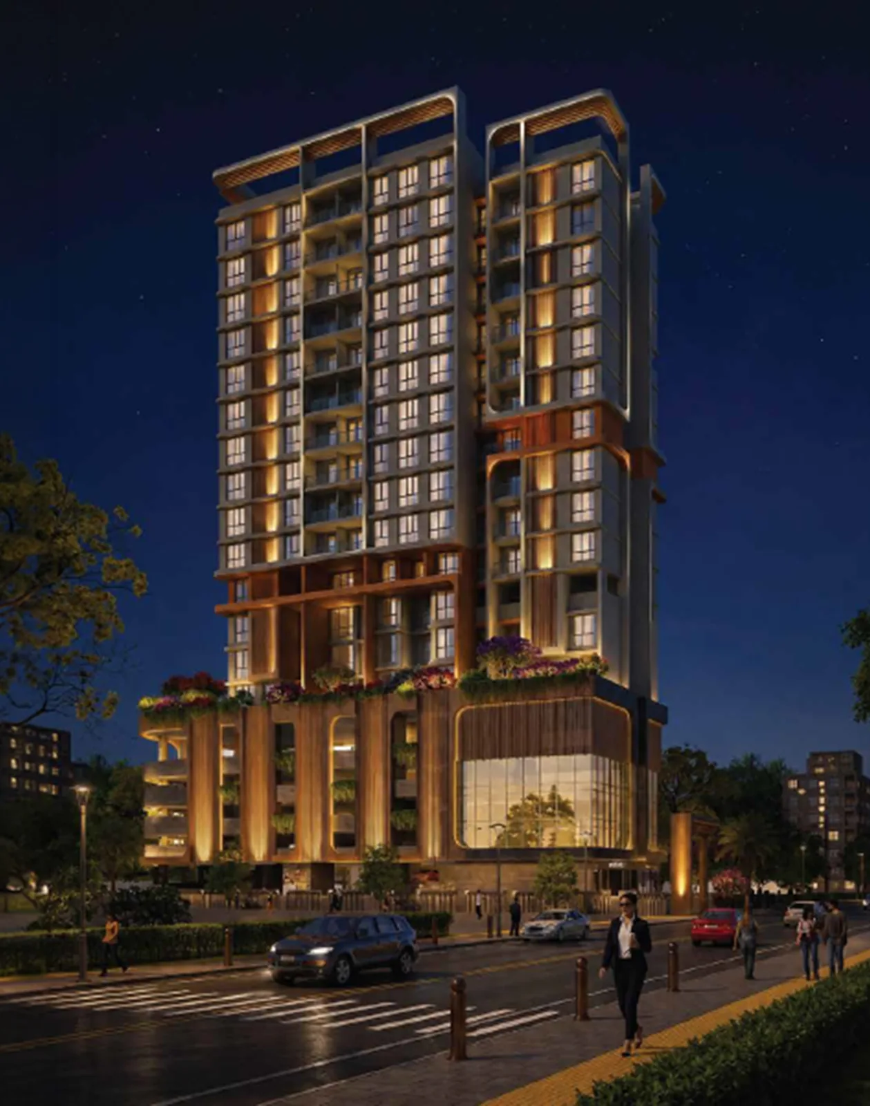 Night view of the Raheja Marques tower, sage concrete and timber-toned fins above a lit glass entrance